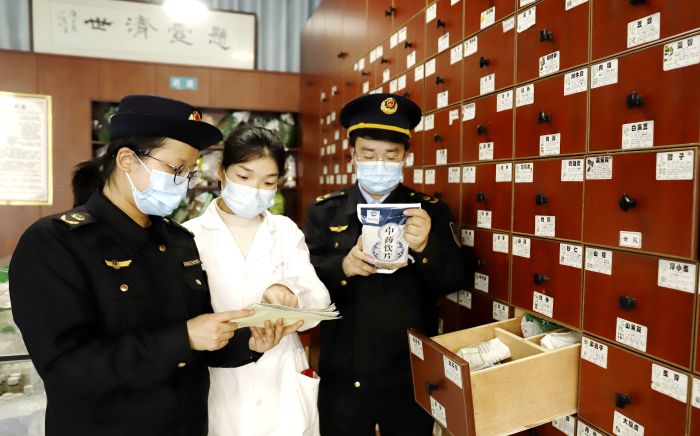 圖為12月12日，該局執(zhí)法人員在一家零售藥店檢查中藥飲片質(zhì)量。