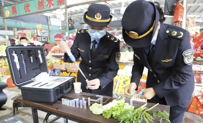 圖為該局執(zhí)法人員對食用農(nóng)產(chǎn)品樣品開展快速檢測。