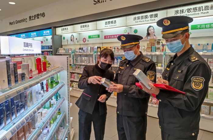 圖為該局執(zhí)法人員在一家化妝品專賣店檢查潤膚霜產(chǎn)品說明。