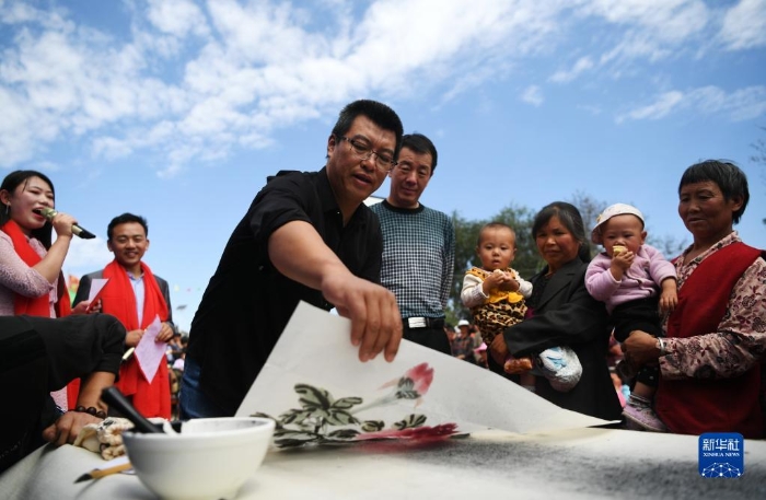 2018年9月8日，在“快樂(lè)一座村莊”送歡樂(lè)下基層公益活動(dòng)中，文藝志愿者郭永東（左三）在甘肅省靜寧縣甘溝鎮(zhèn)梁岔村為村民現(xiàn)場(chǎng)作畫。新華社記者 陳斌 攝