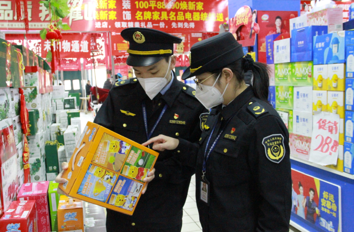 圖為該局執(zhí)法人員在一家商場檢查在售食品是否超過保質(zhì)期。