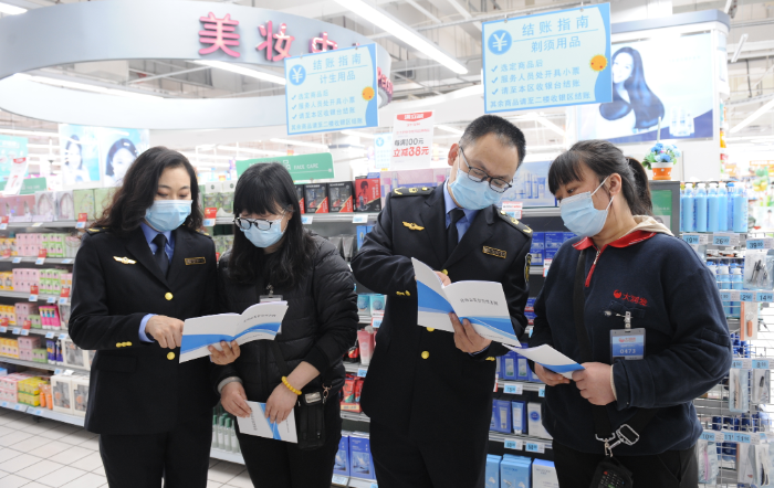 圖為該局執(zhí)法人員在一家大型商超化妝品專柜向經營者宣講。