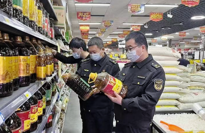 圖為該局執(zhí)法人員在一家超市檢查食用植物油包裝標簽標識。