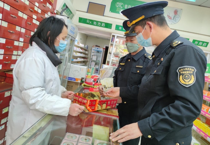 圖為執(zhí)法人員在一家零售藥店檢查中藥飲片是否霉爛變質。