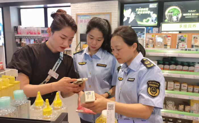圖為該局執(zhí)法人員在一家化妝品專營店開展檢查并指導工作人員操作化妝品監(jiān)管APP。