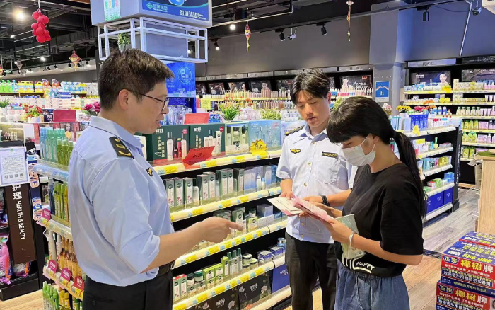 圖為該局工作人員在商場向群眾宣傳化妝品安全知識。