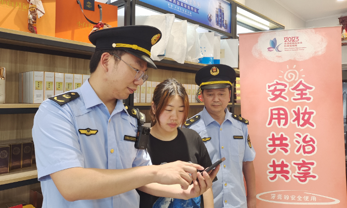 圖為執(zhí)法人員指導(dǎo)經(jīng)營(yíng)戶(hù)使用“數(shù)字辨妝”一體化監(jiān)管平臺(tái)的云管理模塊。