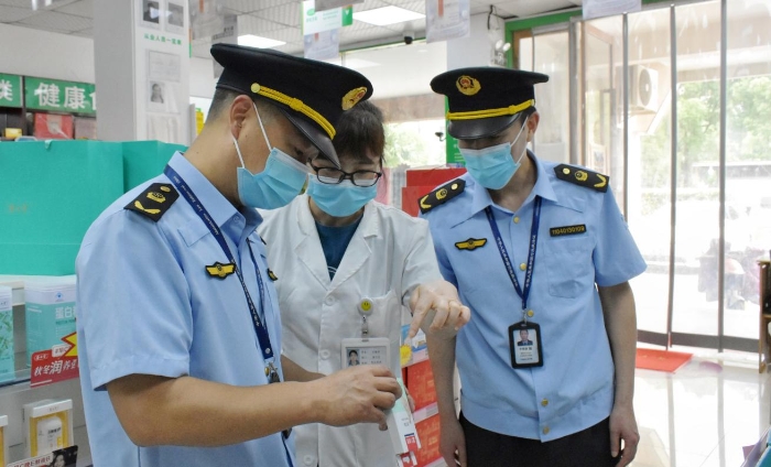 圖為該局執(zhí)法人員正在轄區(qū)內(nèi)一家藥店檢查核對相關(guān)藥品銷售信息。