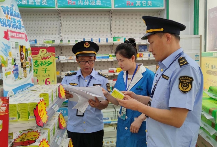 圖為6月5日?qǐng)?zhí)法人員在一家藥店檢查防暑藥品質(zhì)量情況。
