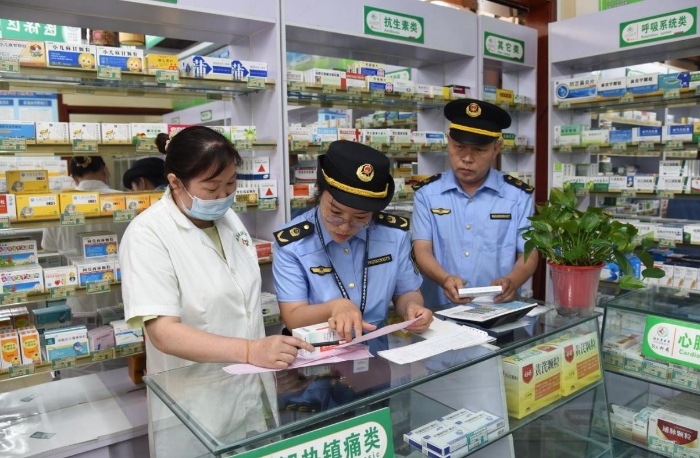圖為執(zhí)法人員在一家藥品零售企業(yè)檢查藥品購進渠道情況。