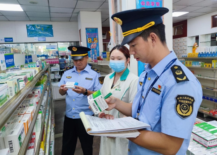 圖為執(zhí)法人員在一家藥店檢查抗病毒藥品質(zhì)量。