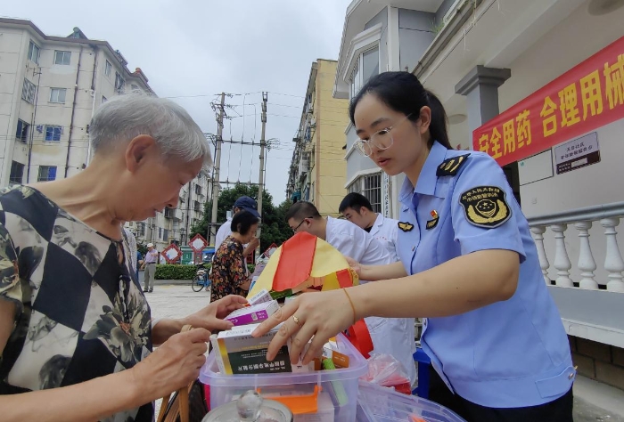 圖為工作人員向社區(qū)咨詢居民講解藥械安全知識。