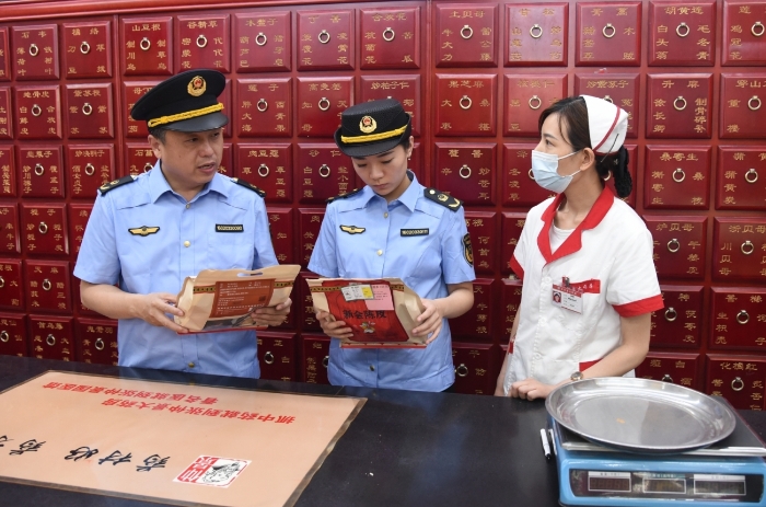 圖為執(zhí)法人員正在一家藥品經(jīng)營企業(yè)抽檢中藥飲片。