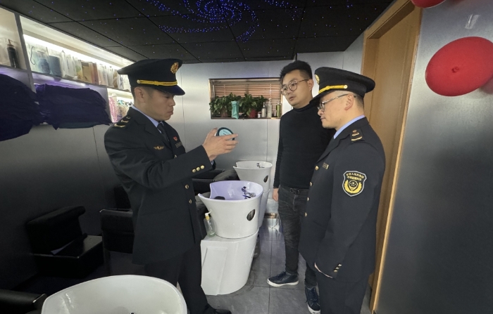 圖為執(zhí)法人員正在一家美容美發(fā)機(jī)構(gòu)進(jìn)行現(xiàn)場(chǎng)檢查。