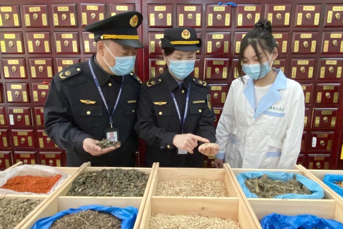 圖為執(zhí)法人員檢查中藥飲片。