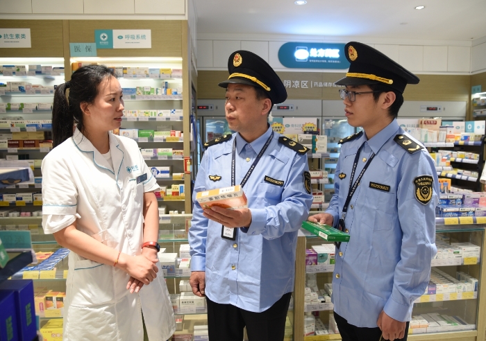 圖為執(zhí)法人員在一家藥店檢查藥品經(jīng)營情況。