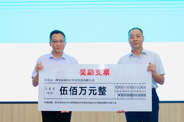圖為研討會(huì)現(xiàn)場，陜西省藥監(jiān)局二級(jí)巡視員王志宏向西安康拓醫(yī)療技術(shù)股份有限公司董事長胡立人頒發(fā)500萬元醫(yī)療器械創(chuàng)新獎(jiǎng)勵(lì)資金。