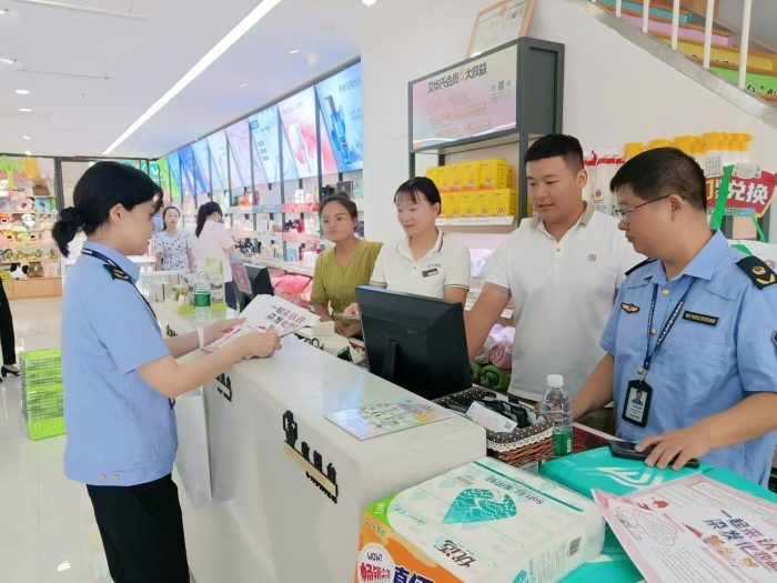 圖為執(zhí)法人員在一家商場(chǎng)發(fā)放宣傳材料。