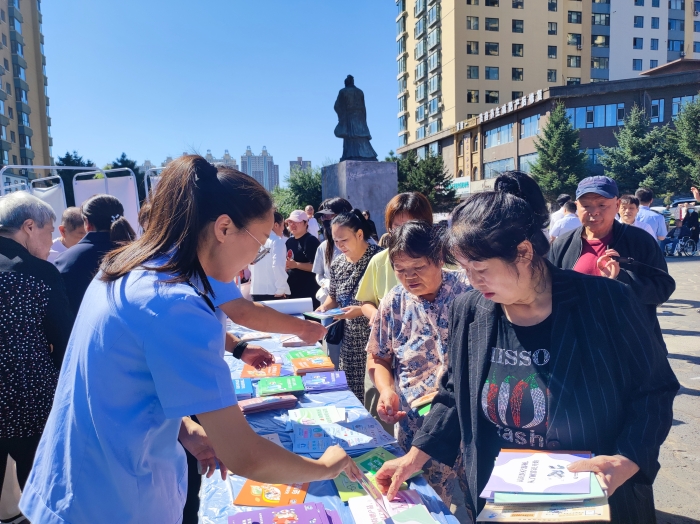 圖為監(jiān)管人員向居民發(fā)放用藥安全科普手冊(cè)