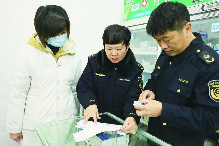 圖②為2024年1月30日，在藥品檢查專項行動中，衡陽市市場監(jiān)管局工作人員正在零售藥店查看臺賬資料。